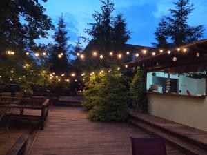 a patio with lights and tables and benches at night at Pensiune Excelenta in Vermeşti +4 photos