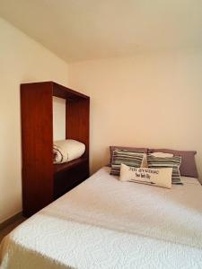 a small bedroom with a bed with a wooden cabinet at Departamento Centrico Iguazu 2B in Puerto Iguazú