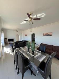 a living room with a dining table and a ceiling fan at Sunrise Villa Self Catering and Accommodation in Lüderitz +6 photos
