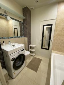a bathroom with a washing machine and a sink at SeaSand in Jūrmala