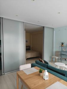 a living room with a blue couch and a bedroom at SeaSand in Jūrmala