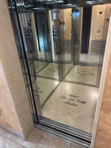 a group of glass doors with writing on the floor at Hotel De La Ville Relais in Fiumicino