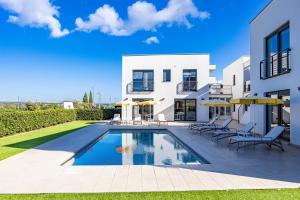 a villa with a swimming pool in front of a house at Villa del Mar in Pula