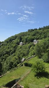 a green hill with houses on top of it at L'hostellerie de la vallée in Gimel