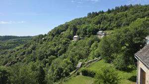 a view of a hill with houses and trees at L'hostellerie de la vallée in Gimel