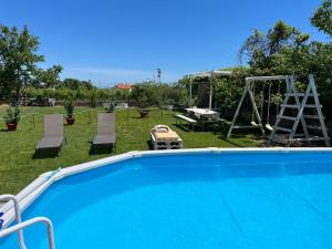 a swimming pool in a yard with chairs and a swing at SlowCasa - VILLA Garden & Pool - Full Apartment in Torrevecchia Teatina