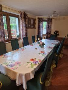 a dining room table with a floral table cloth on it at Bylew Zacisze in Licheń Stary