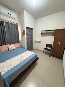 a bedroom with a bed and a chair in it at Casa Temporada Aconchego e tranquilidade 2 in Bonito +22 photos