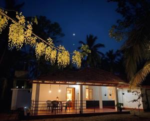 a man sitting at a table in front of a house at night at Aqua Bliss Resort & Villa Bentota in Bentota
