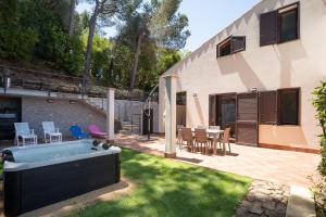 a backyard with a hot tub in the grass at Breathtaking Sea Views & Jacuzzi in Cefalù in Cefalù
