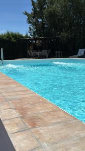 a swimming pool with blue water and a wooden floor at La Zagala in Badajoz