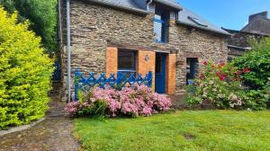 a brick house with a blue gate and flowers at Penty horizon de Brocéliande in Augan +17 photos