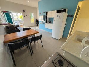 a kitchen with a wooden table and a refrigerator at Casa Temporada Aconchego e tranquilidade 2 in Bonito