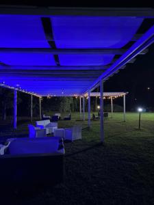 a group of tables and chairs under a blue lights at Artemide Resort Spa - Private Villa in Lido Di Fondi