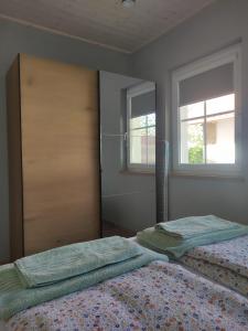 a bedroom with two beds and two windows at Strázsa Porta in Monor