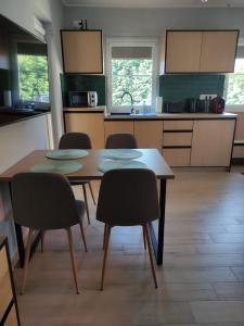 a kitchen with a table and four chairs in it at Strázsa Porta in Monor