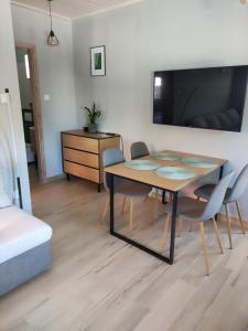 a dining room with a table and chairs and a tv at Strázsa Porta in Monor
