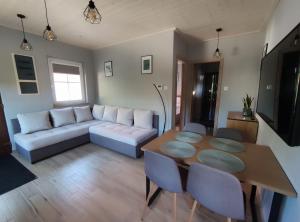 a living room with a couch and a table at Strázsa Porta in Monor