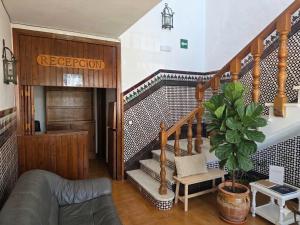 a living room with a staircase with a potted plant at Hotel Apolo XI in Tahivilla