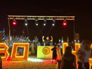 a man standing on top of a stage at night at Rose Garden Premium - Ultra All Inclusive in Kemer +172 photos