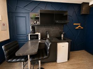 a kitchen with a black counter and blue walls at Studio Royal Saint-Omer Centre in Saint-Omer