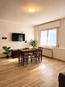 a dining room with a table and chairs and a tv at borgo nel vigneto 2 in Erbusco