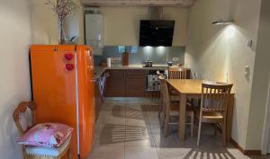a kitchen with an orange refrigerator and a table at Melluzi Seaside Residence in Jūrmala