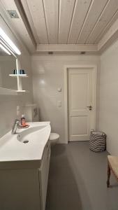 a bathroom with a white sink and a toilet at Melluzi Seaside Residence in Jūrmala +4 photos