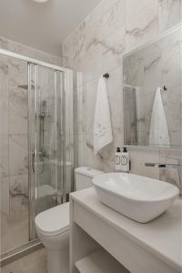 a bathroom with a sink and a toilet and a shower at Papi Boutique Hotel in Vathí +73 photos