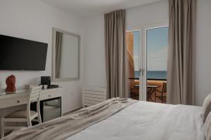 a hotel room with a bed and a desk with a computer at Papi Boutique Hotel in Vathí