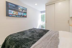 a bedroom with a bed with a tv on the wall at Tokio Loft Loft Moderno en Centro de Durango in Durango