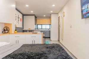 a kitchen with white cabinets and a large rug at Tokio Loft Loft Moderno en Centro de Durango in Durango +18 photos