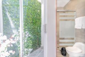 a bathroom with a toilet and a glass door at Tokio Loft Loft Moderno en Centro de Durango in Durango