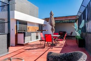 a patio with chairs and a table and an umbrella at Tokio Loft Loft Moderno en Centro de Durango in Durango