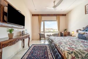 a hotel room with a bed and a large window at Mangal Residency Rooftop Pool in Udaipur