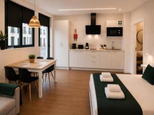 a room with a bed and a table and a kitchen at Social Lodge Cabouqueira Studios in Funchal
