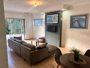 a living room with a couch and a tv at 16 st Johns - Apartment in Port Shepstone