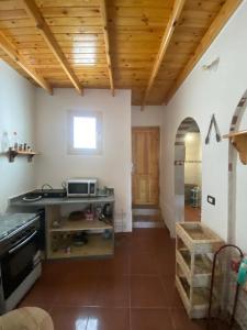 a kitchen with wooden ceilings and a table with a microwave at Bedro Private Garden Studio & Outdoor Lounge 1 Min to Sea in Dahab