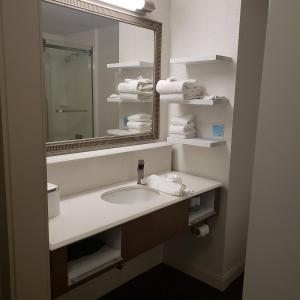 a bathroom with a sink and a mirror and towels at Dyersburg Hotel in Dyersburg +6 photos