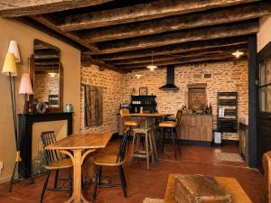 a kitchen with wooden tables and chairs in a room at Studio Rétro in Tournus