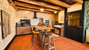 a kitchen with a wooden table and some chairs at Studio Rétro in Tournus +21 photos