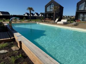 a large swimming pool with a bench and a house at Palmera in Władysławowo