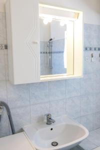 a bathroom with a white sink and a mirror at Holiday house Bruno in Savar +18 photos