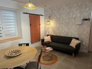 a living room with a couch and a table at Résidence le 1564 Terracotta in Roussillon en Isere