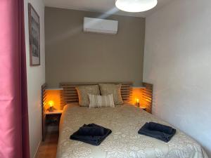 a bedroom with a bed with two towels on it at Résidence le 1564 Terracotta in Roussillon en Isere