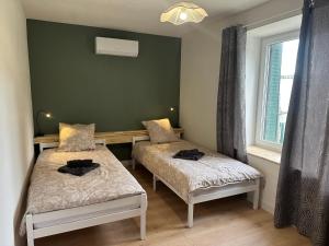 a room with two beds and a window at Résidence le 1564 Terracotta in Roussillon en Isere