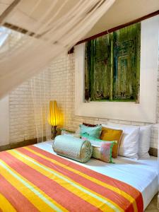 a bedroom with a bed with colorful pillows at GODDESS Kandy in Kandy