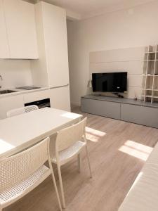 a kitchen with a table and chairs and a television at residenza MINERVA & swimming pool in Aprilia Marittima