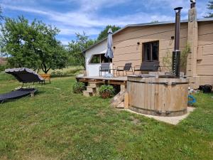 a cabin with a hot tub and a grill in the yard at Chatka U Vlka in Lnáře