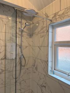 a shower in a bathroom with a window at Rooms at 153 ROOM ONLY in Scarborough
